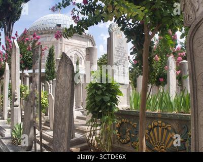 Ottomanischer Friedhof Grabsteine und Türbe - historische ottomanische Grabsteine mit Kalligraphie und Schnitzereien stehen inmitten von Laub auf einem friedlichen Friedhof, eingerahmt Stockfoto