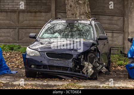 Ein kaputtes schwarzes Auto wurde nach einem Unfall zu einem Autounfall gebracht. Die Karosserie des Wagens wurde nach der Kollision zerstört. Stockfoto