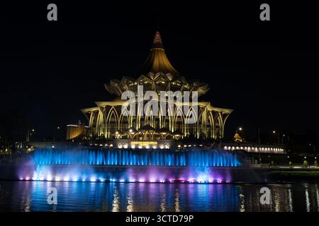 Nachtansicht auf die beleuchtete Sarawak State Assembly mit Reflexionen in Kuching, Borneo Stockfoto