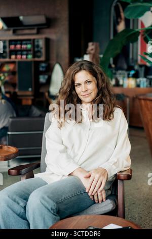 Porträt einer schönen rothaarigen Frau von 35 Jahren, die in einem Kaffeehaus sitzt. Stockfoto