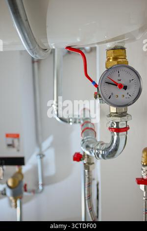 Manometer, das den aktuellen Barstand in einem komplexen System von Wasserleitungen und Ventilen anzeigt. Stockfoto