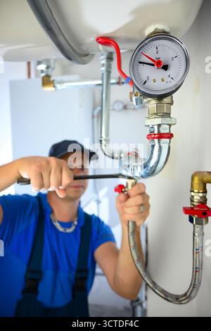 Klempner prüfen ein Manometer beim Einbau oder Reparieren von Rohrleitungen. Stockfoto