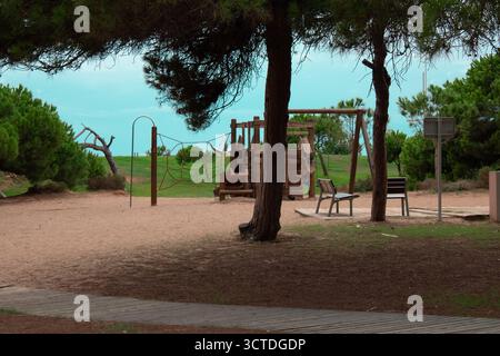 Kinderspielplatz umgeben von Kiefern in Castelldefels an der Küste Barcelonas Stockfoto