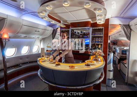 Eine Stewardess serviert hinter der Getränke- und Erfrischungsbar auf dem Oberdeck im Business-Class-Bereich des Emirates Airbus 380 Stockfoto
