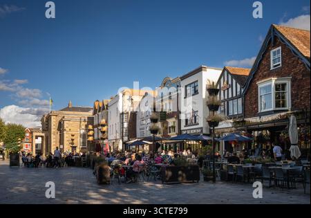 Salisbury, Wiltshire, Vereinigtes Königreich: Der Marktplatz im Zentrum von Salisbury mit Ox Row und Guildhall. Die Leute sitzen vor den lokalen Pubs und genießen einen Drink Stockfoto