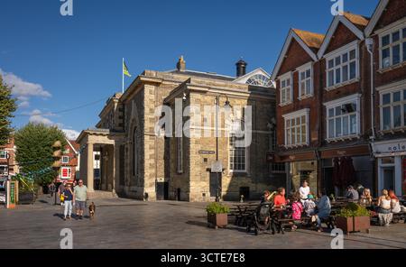 Salisbury, Wiltshire, Vereinigtes Königreich: Der Marktplatz im Zentrum von Salisbury mit Guildhall und Ox Row. Die Leute sitzen vor einem Restaurant und essen. Stockfoto
