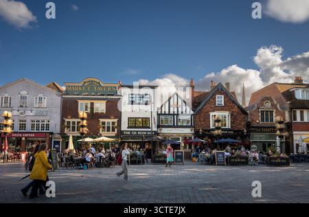 Salisbury, Wiltshire, Großbritannien: Der Marktplatz im Zentrum von Salisbury mit Ox Row. Die Leute sitzen vor den lokalen Pubs und genießen einen Drink in der Abendsonne Stockfoto
