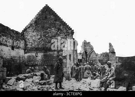 Seite aus Le Miroir, 5. November 1916, zeigt eine Gruppe von Männern, die in den Ruinen eines Hauses oder einer Kirche in Emberménil oder Vitrimont stehen, wo Zivilisten, darunter Frauen wie Maria Camesat, 1914 von deutschen Truppen hingerichtet wurden. Der Ort der Verwüstung, an dem Männer feierlich inspiziert werden, spiegelt sowohl die Zerstörung der besetzten Dörfer als auch das Gedenken an die Opfer der Gräueltaten im Nordosten Frankreichs wider. Stockfoto