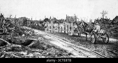 Seite aus Le Miroir, 5. November 1916, zeigt einen von Maultieren gezogenen Konvoi, der Munitionsgranaten durch ein Ruinendorf an der Somme-Front während des Ersten Weltkriegs transportierte. Jeder Wagen trägt schwere Artilleriesets, um die französisch-britischen Truppen zu versorgen, die in der Schlacht eingesetzt wurden. Das Bild veranschaulicht die unnachgiebige logistische Anstrengung hinter der Offensive, wobei kleine Karren in verwüstetem Gelände wichtige Unterstützung bieten und es den Truppen ermöglichen, die Feuerkraft in der Nähe der Frontlinien aufrechtzuerhalten. Stockfoto