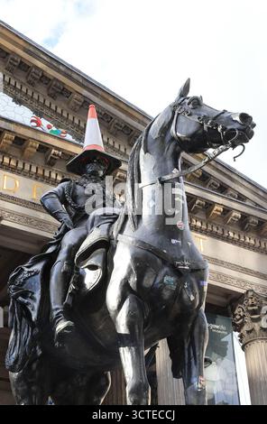 Duke of Wellington Statue mit einem berühmten Verkehrskegel auf dem Kopf, außerhalb der Gallery of Modern Art, die Tradition begann in den 1980er Jahren und ist symbolisch für Glasgows respektlosen Humor, Schottland. Stockfoto
