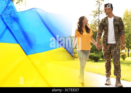 Glücklicher Militärmann und seine Freundin gehen draußen. Doppelte Exposition mit Flagge der Ukraine Stockfoto