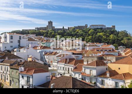 Panoramablick auf die charmante Stadt Palmela, Portugal, mit ihren traditionellen Häusern und dem historischen Schloss Palmela, das sich auf dem Hügel befindet Stockfoto