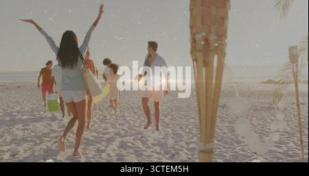 Winkende Strandgänger in weißen Shorts begrüßen Freunde am Sandstrand mit Surfbrett und Windlichtern Stockfoto