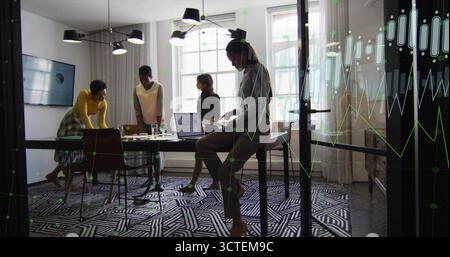 Eine Geschäftsfrau, die im Konferenzraum ein graues Hemd auf dem Hocker trägt, liest Dokumente auf dem Laptop Stockfoto