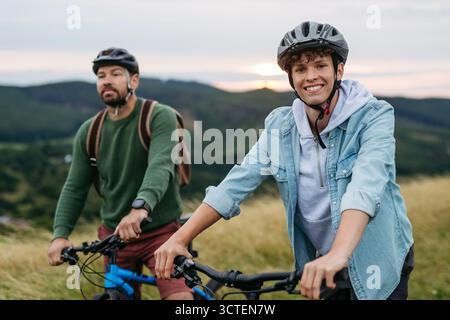 Vater und Teenager fahren in den Bergen Fahrrad. Radtour am Herbsttag. Stockfoto