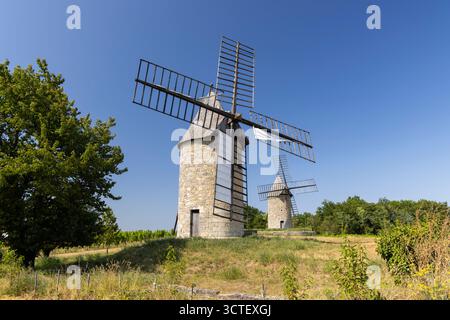 Zwei alte Windmühlen stehen auf einem sonnigen Hügel in Montagne, Gironde, Frankreich Stockfoto