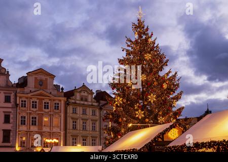 Der Prager Altstädter Platz mit festlichem Weihnachtsmarkt und einem hell erleuchteten Weihnachtsbaum in der Abenddämmerung Stockfoto