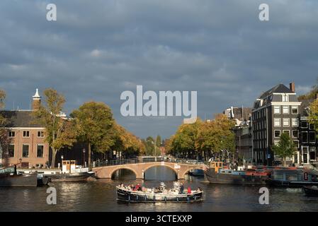 Flussrundfahrt Sightseeing Boot auf der Amstel Herengracht am frühen Abend, Amsterdam, Niederlande Stockfoto