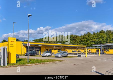 Hanstedt, Deutschland; 30. September 2025: DHL Deutsche Post-Verteilerzentrum mit gelben Lieferwagen, die draußen geparkt sind, symbolisieren Logistik, Liefernetz Stockfoto