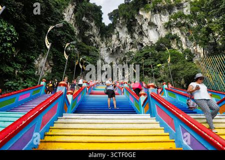 Batu Caves, Malaysia - 16. November 2018: Blick auf die lebendige Treppe, die zu den Tempelhöhlen führt, ein Farbenaufstand vor der Kulisse der majestätischen Kalksteinklippen. Stockfoto