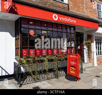 Straßenblick auf ein Vodafone Einzelhandelsgeschäft in der Marlborough High Street mit leuchtend roter Fassade und Beschilderung an einem sonnigen Tag Stockfoto