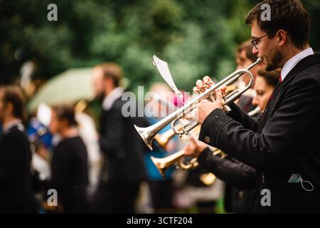 München, Deutschland - 18. September 2022: Blick auf die pulsierende Oktoberfestparade, Trompeten glitzern unter dem bewölkten Himmel, eine jubelnde Feier des bayerischen Erbes. Stockfoto