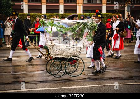 München, Deutschland - 18. September 2022: Blick auf die jubelnde Oktoberfestparade, wo traditionelle bayerische Kleidung auf moderne Regenschirme trifft Stockfoto