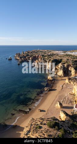 Praia de Dona Ana Strand in der Nähe von Lagos Stadt, Algarve, Portugal. Praia Dona Ana Strand mit türkisfarbenem Meerwasser und Klippen, Portugal. Drohne aus der Luft. Stockfoto