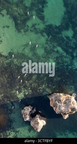 Portugal, Algarve. Klippen und Meer, von oben aus der Vogelperspektive auf Leute, die Paddelbrettsup machen Stockfoto