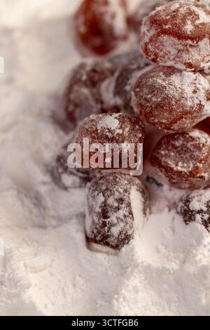 Getrockneter Kumquat und weißer Puderzucker, süße getrocknete Orangen-Kumquat-Früchte in weißem Puderzucker, Nahaufnahme Stockfoto