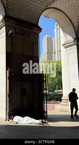 Obdachloser schläft auf der eingangsplatte des New York City Regierungsgebäudes in der 1 Centre Street in Downtown Manhattan, New York City. Stockfoto