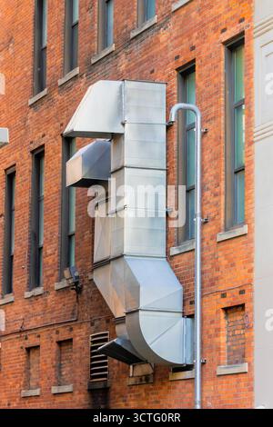 Große industrielle Lüftungskanäle an der roten Ziegelwand des Gebäudes. Stockfoto