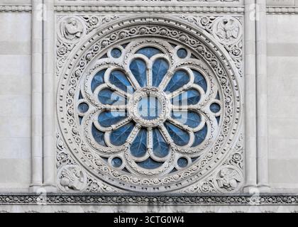 Detaillierte Ansicht des kunstvollen Rosenfensters mit floralem und kreisförmigem geometrischem Muster der St. Aloysius Parish Church in Detroit downton. Stockfoto