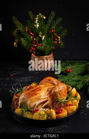 Gebackenes Huhn oder truthahn. Tischeinstellung. Gebratenes Hähnchen mit Kartoffeln und Weihnachtsdekoration. Weihnachtsessen Stockfoto