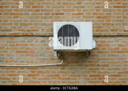 Die externe Einheit einer Klimaanlage, die an der Außenwand eines Hauses hängt Stockfoto