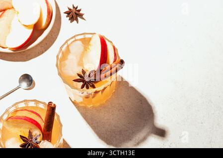 Apfelcocktail im Herbst oder Mocktail-Getränk. Apfelwein mit Zimt und Anis auf weißem Hintergrund, Kopierraum. Stockfoto