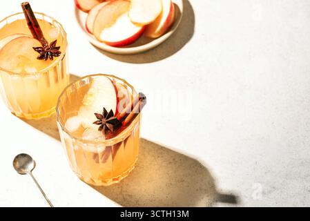 Apfelcocktail im Herbst oder Mocktail-Getränk. Apfelwein mit Zimt und Anis auf weißem Hintergrund, Kopierraum. Stockfoto