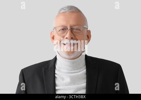 Porträt eines Geschäftsmannes in Brille auf grauem Hintergrund Stockfoto