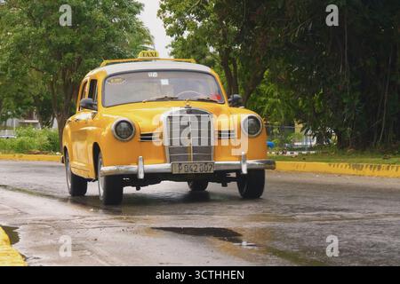 1962 Mercedes-Benz 190C gelbes Taxi. Gelbes, antikes Auto, Vorderansicht auf Kuba. Oldtimer-Taxi in den Straßen Kubas aus nächster Nähe. Auto in kubanisches Taxi umgewandelt. Varadero, Kuba - 14. Januar 2022 Stockfoto