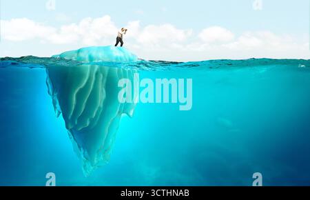 Geschäftsmann mit Fernglas auf einem Eisberg Stockfoto