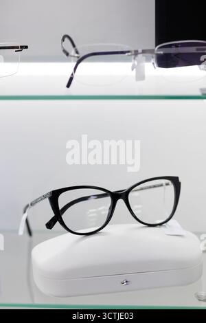 Eine elegante schwarze Katzenbrille liegt elegant auf einer Vitrine und lädt Kunden ein, die modische Brillen zu entdecken. Stockfoto