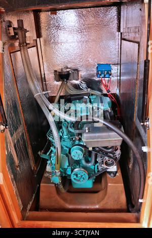 Ausrüstung für kleine Yachten: Typischer Innenborddieselmotor in einem kleinen isolierten Raum. Stockfoto