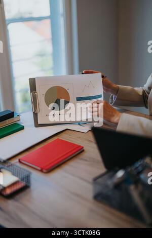 Ein junges Paar diskutiert mit einem Finanzberater in einer Bankfiliale über Darlehensoptionen Stockfoto