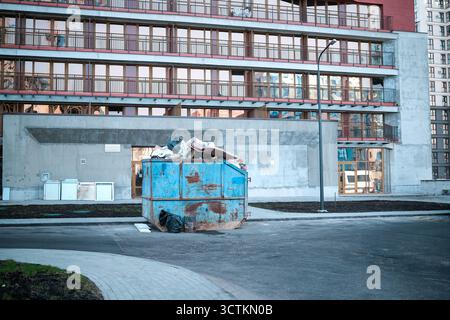 Bauabfallbehälter vor dem Hintergrund eines mehrstöckigen Gebäudes Stockfoto