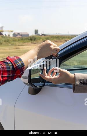 Mann hält den Türgriff des Autos, Schlüssel in der Hand Stockfoto