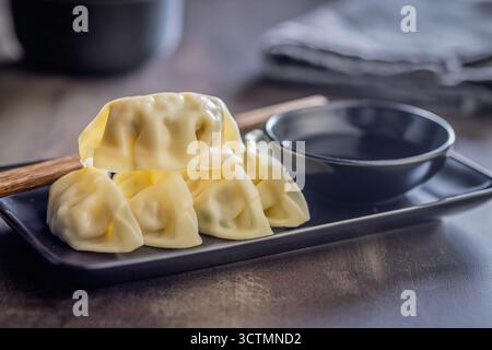 Traditionelle japanische Gyoza-Knödel und Sojasauce auf einem Küchentisch. Stockfoto