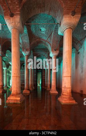 Die Zisterne der Basilika in Istanbul zeigt endlose Reihen von antiken Säulen, die sich in ruhigem Wasser spiegeln, und schafft so eine geheimnisvolle unterirdische Szene. Stockfoto