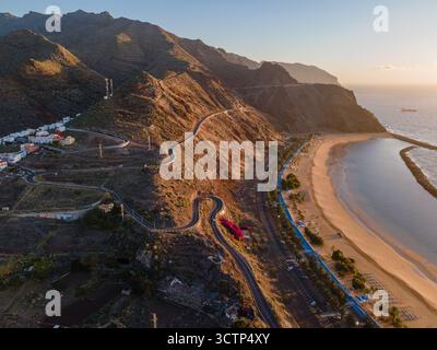 Aus der Vogelperspektive auf eine gewundene Bergstraße entlang der Südküste Teneriffas in der Nähe von San Andrés, mit dramatischen Klippen und dem Meer Stockfoto