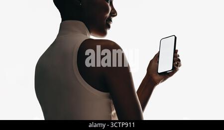 Nahaufnahme einer Frau, die ein Smartphone mit leerem Bildschirm hält, isoliert auf weiß. Perfekt für App- und UI-Modelle, Technologiepräsentationen und Stockfoto