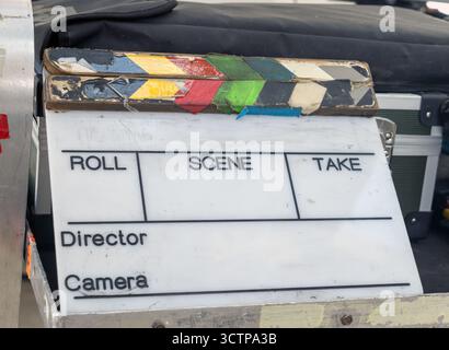 Eine klassische Filmproduktionsklappertafel auf einem Tisch neben Ausrüstung für die Filmherstellung Stockfoto